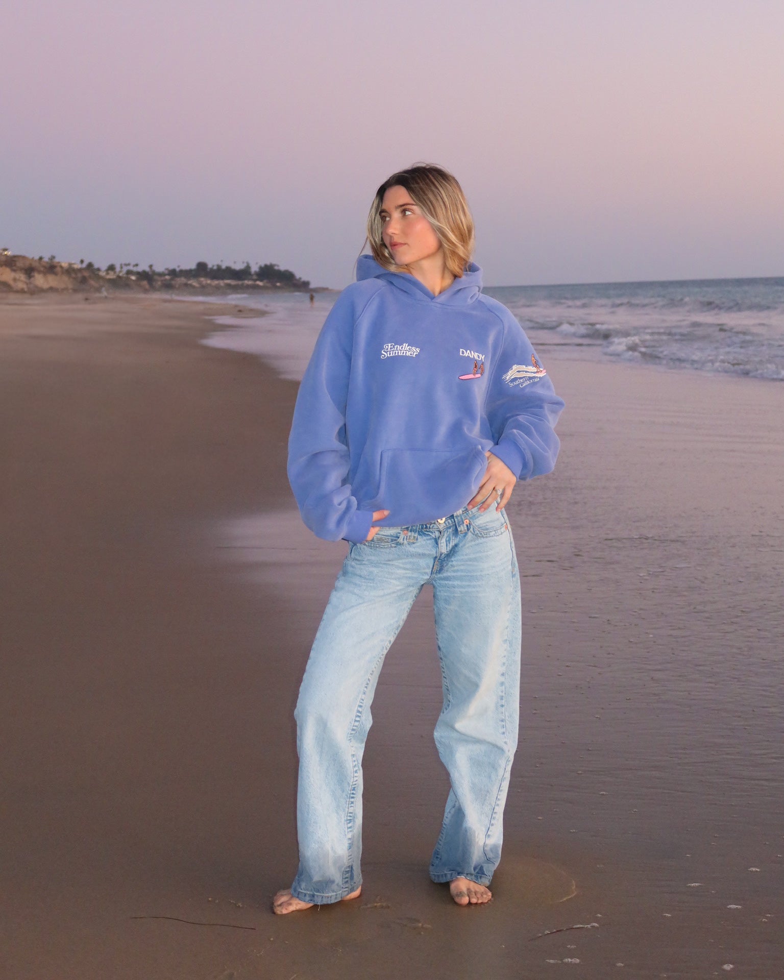 "Endless Summer" Oversized Lux Hoodie in Vintage Washed Blue showing the front of the hoodie on the beach