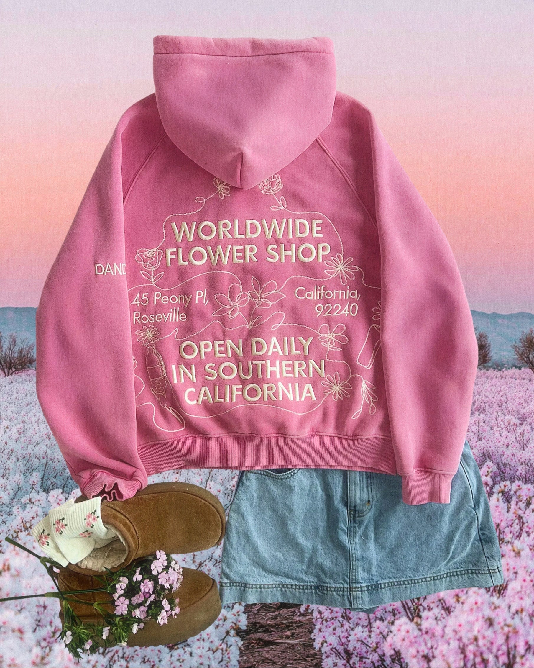 Photo shows a flat lay of a pink flower hoodie, blue denim skirt, and brown Uggs against a graphic background of a flower field.