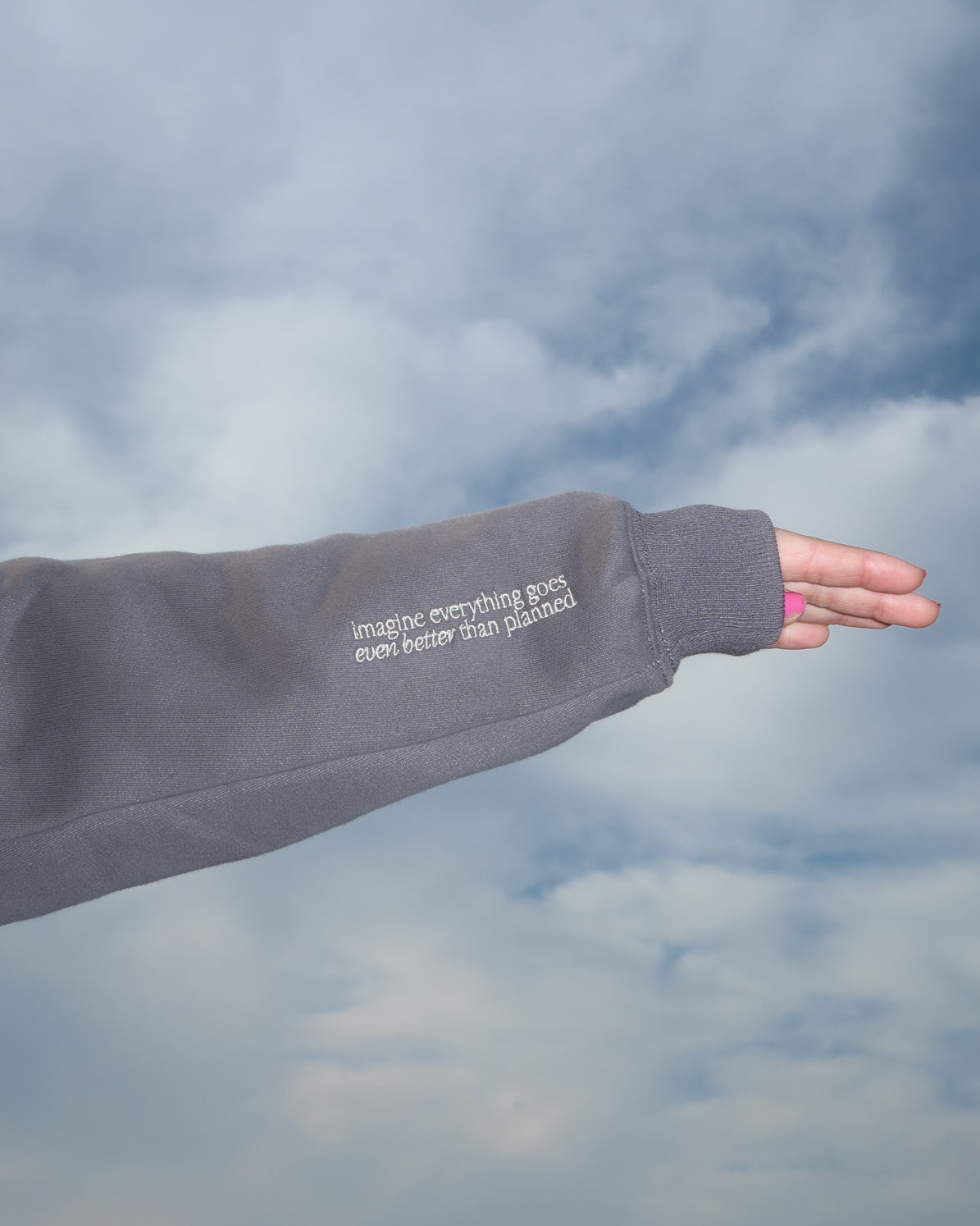Gray sleeve with text against a cloudy sky