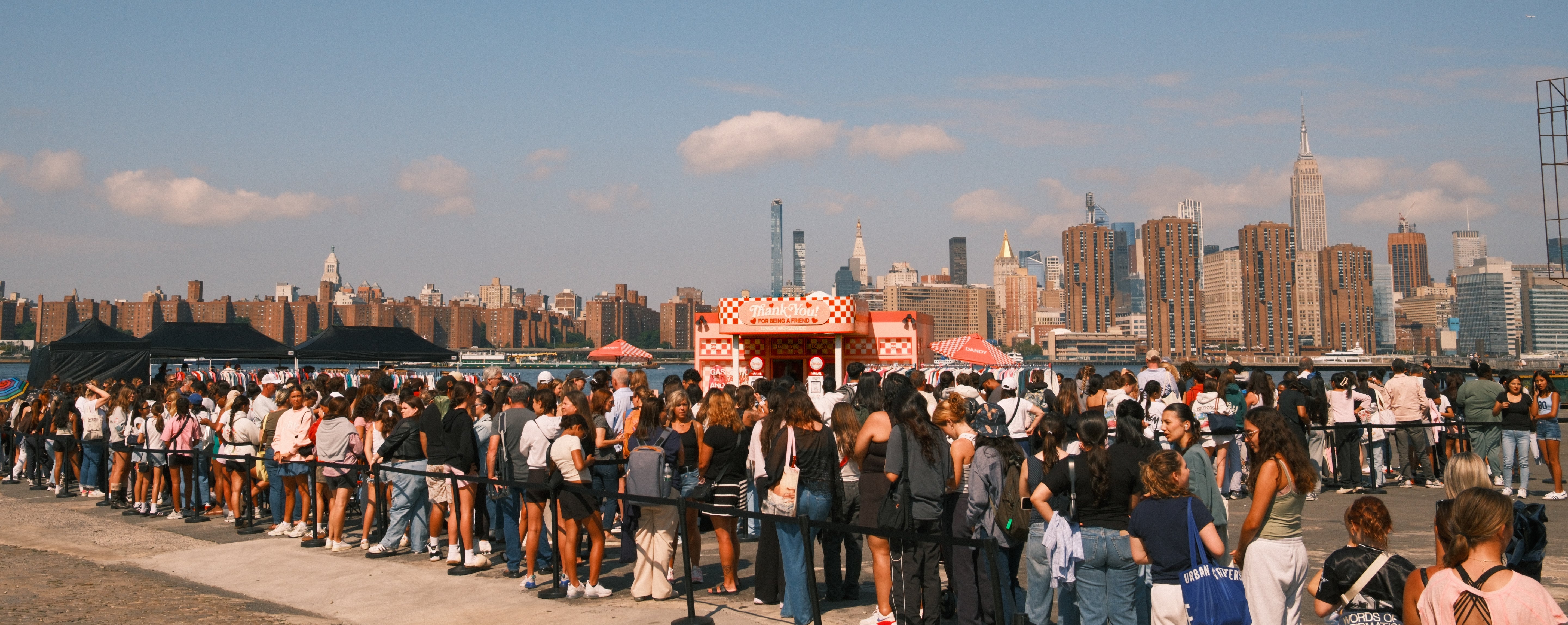 Large crowd of people on a rooftop with a city skyline in the background