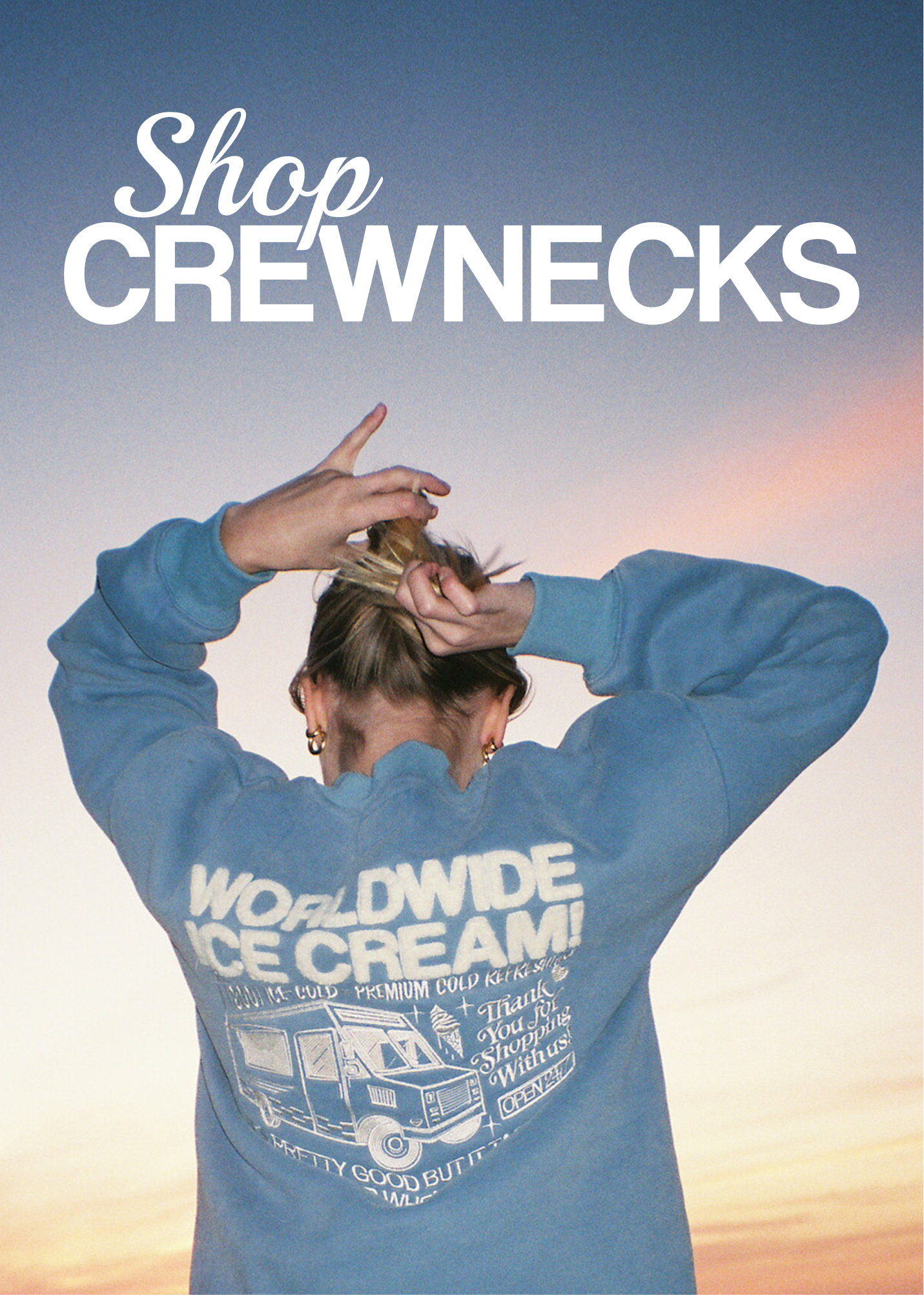 Clickable image with text overlay that reads 'Shop Crewnecks'. Image shows a girl wearing a blue sweatshirt with 'Worldwide Ice Cream' embroidered on it.