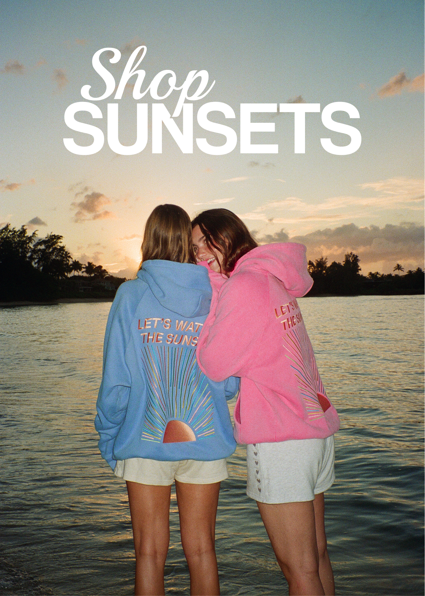 CLICKABLE IMAGE THAT READS: "SHOP SUNSETS" overlayed. Two girls wearing matching "SUNSET" hoodies by the beach.
