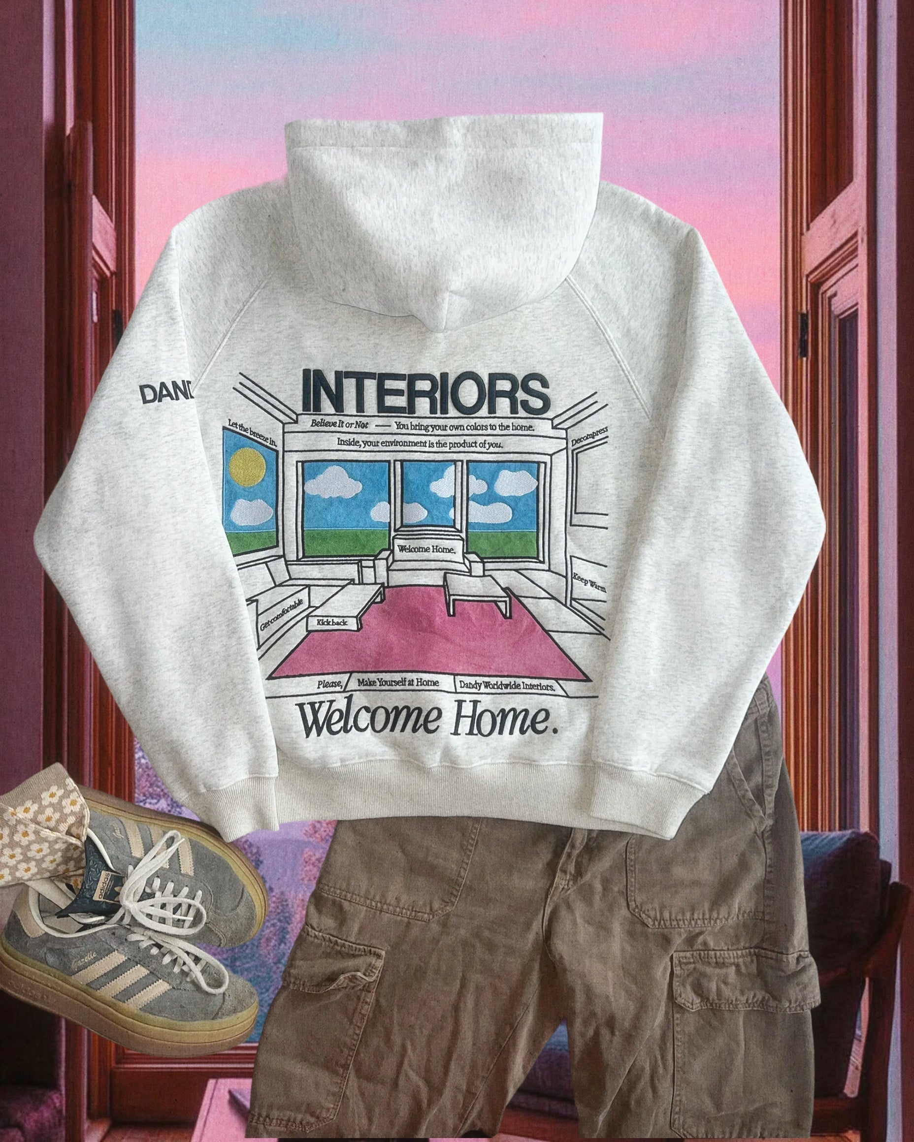 White hoodie with graphic design on a chair against a colorful window background
