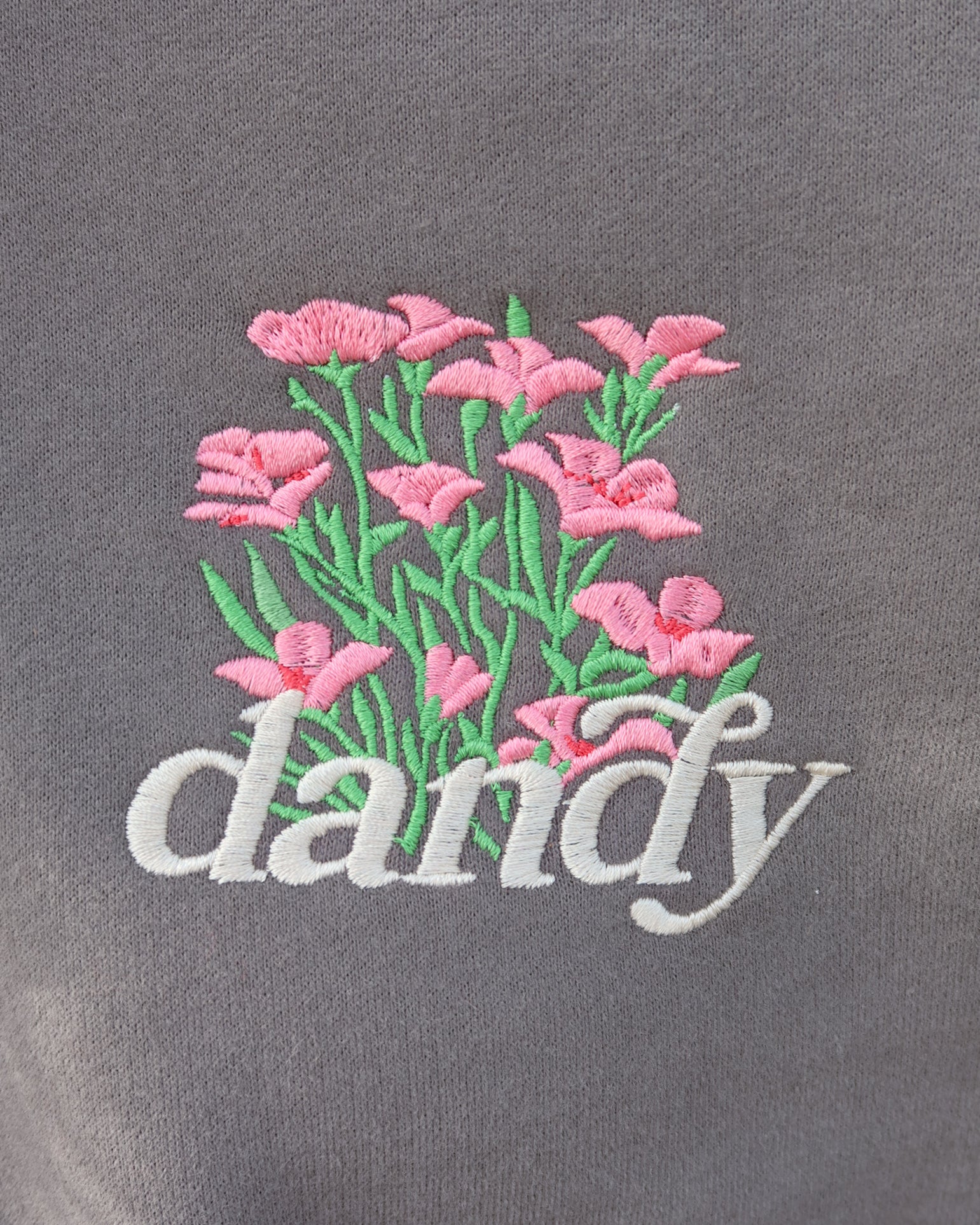 Embroidered pink flowers and the word 'dandy' on a gray background