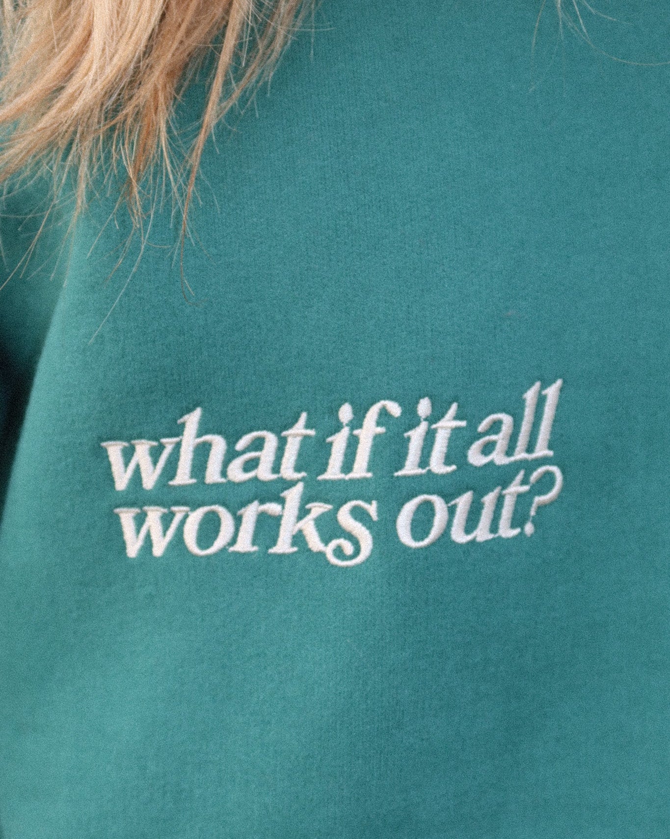 Teal sweatshirt with 'what if it all works out?' text in white