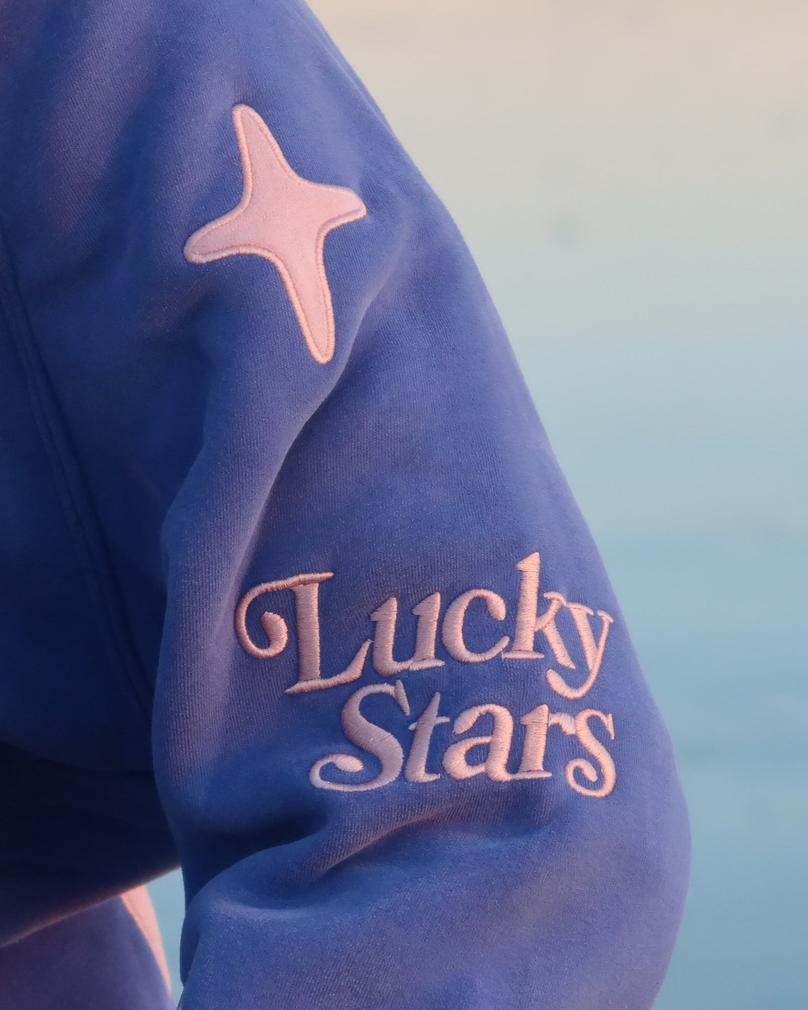 Blue jacket with pink star and 'Lucky Stars' text on a blurred background